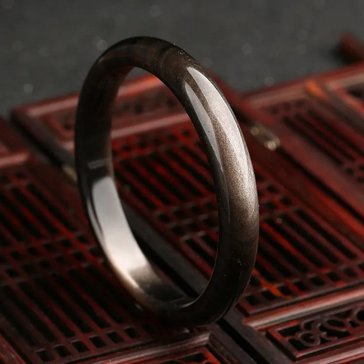 Natural silver stone cat's eye bracelet with ethnic geometric design on a wrist.