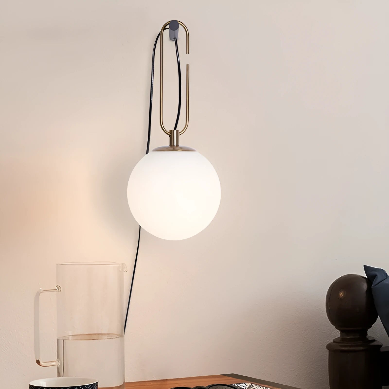 Modern Nordic-style glass wall lamp on a white wall, showing clean lines and translucent glass construction.
