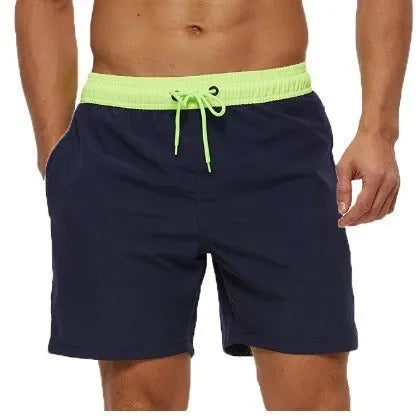 Men's blue training shorts with stitching waist detail, zippered pockets, and an included grey headband.