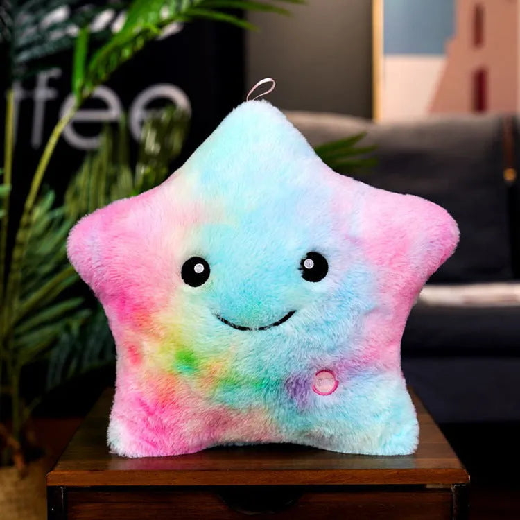 Colourful glowing five-pointed star plush pillow on a dark background, showing soft texture and LED illumination
