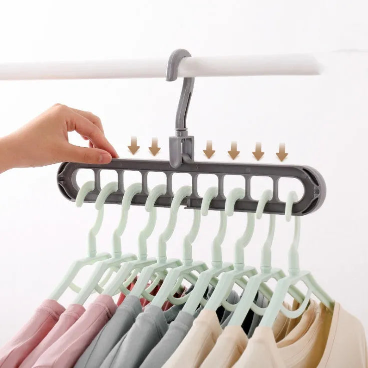Plastic clothes hanger with rotating hook in pink colour, shown next to a green hanger.