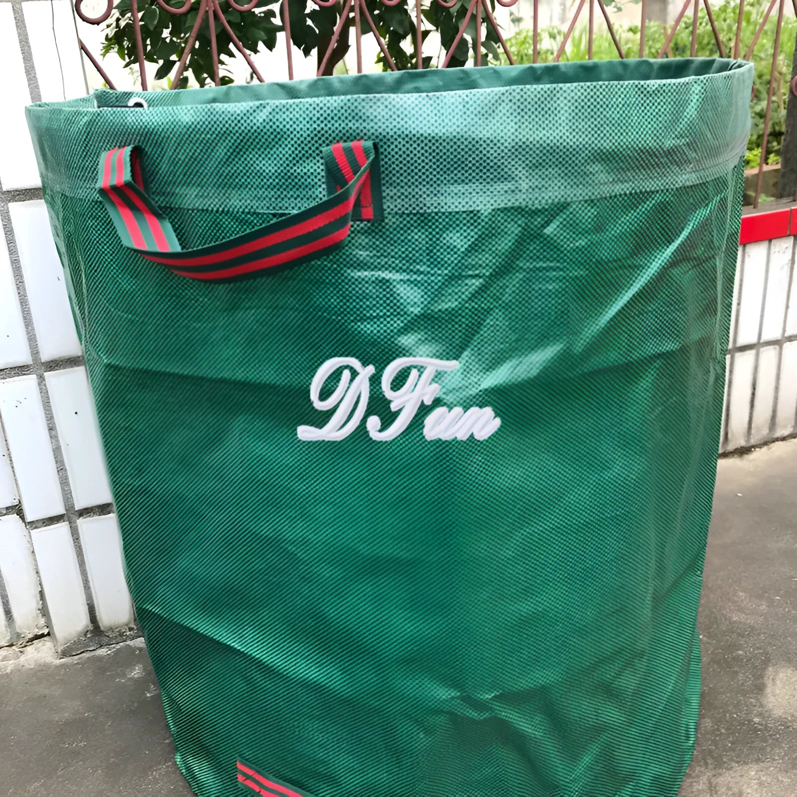 Green polypropylene garden leaf bag for collecting fallen leaves and garden waste.