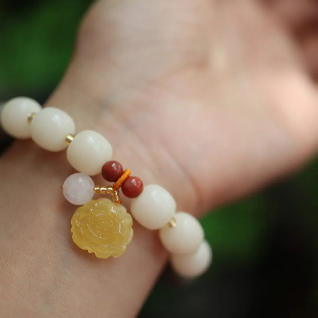 Women's Bodhi root bracelet with gradient white jade beads and a natural beeswax lotus pendant.