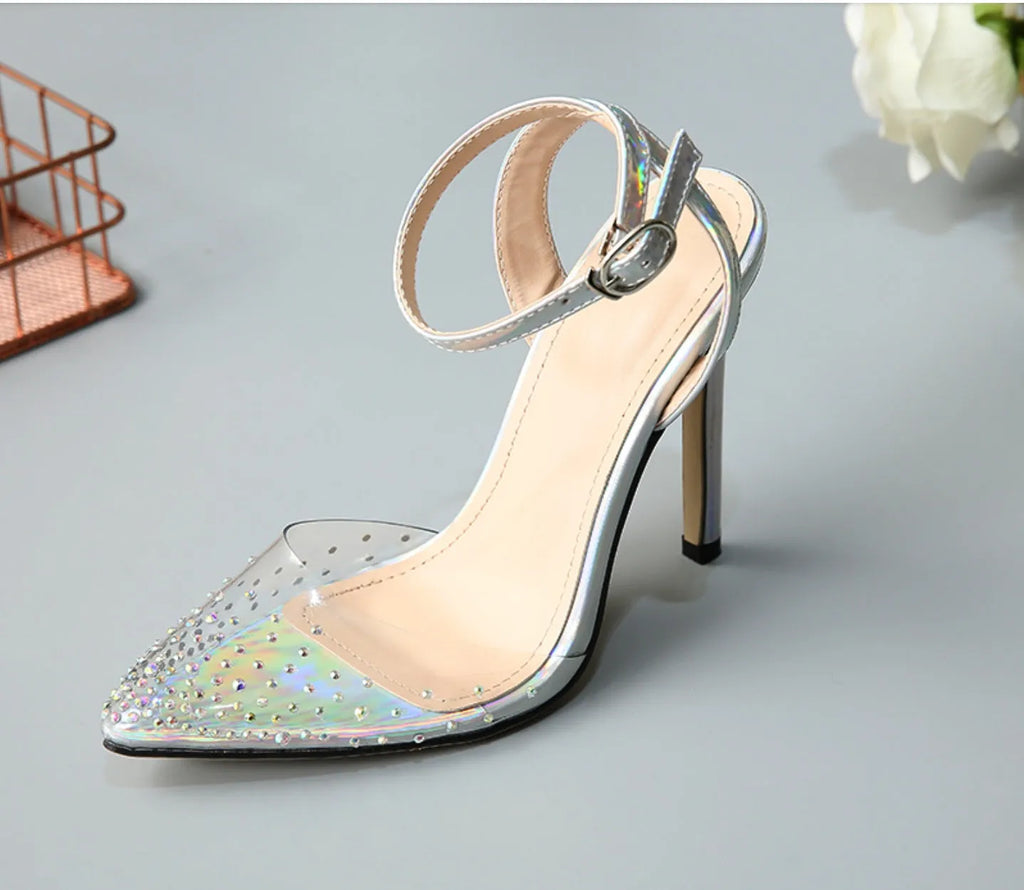 Clear PVC women's sandals with a pointed toe and a thin 10cm stiletto heel on a plain background.