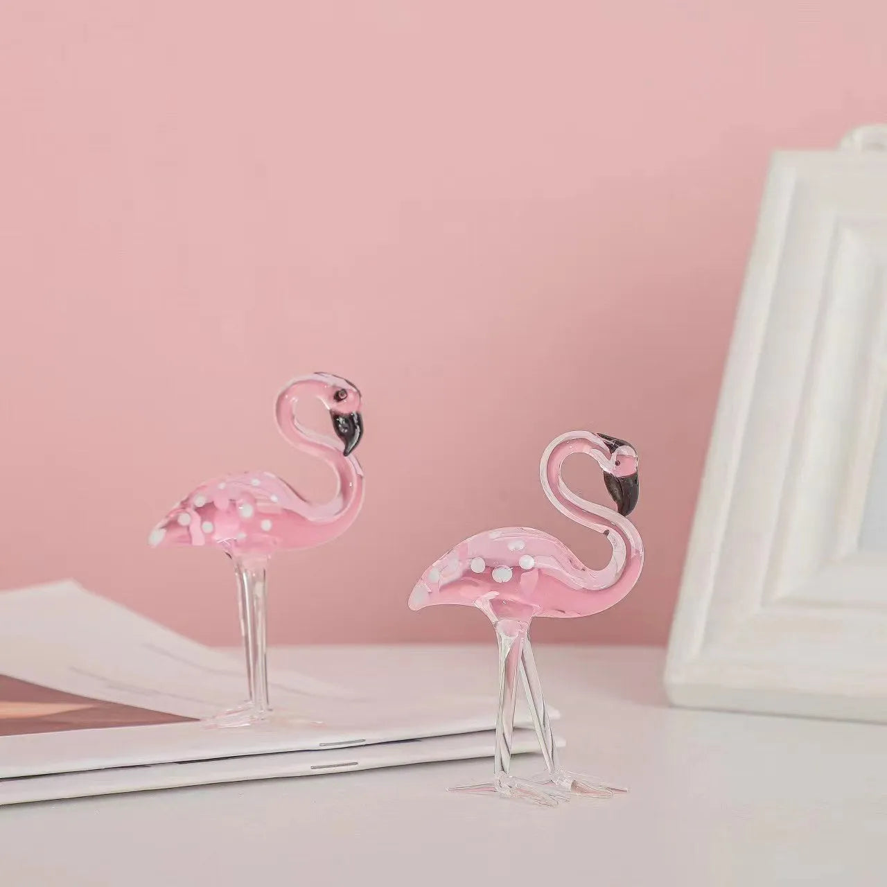 Pink crystal flamingo decorative ornament on a table for modern home decor.