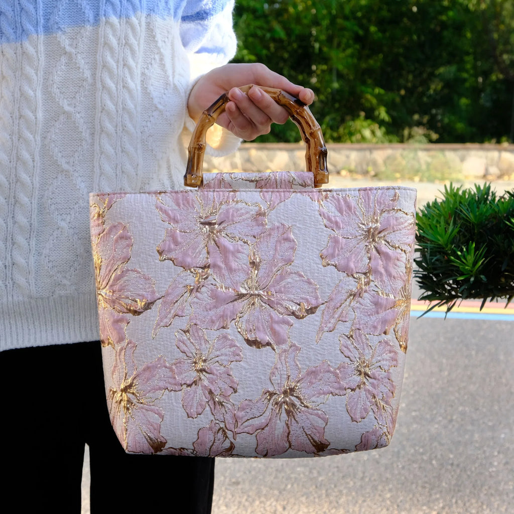 Light blue canvas bag with gold bronzing flower pattern, horizontal square shape, and dual shoulder straps.
