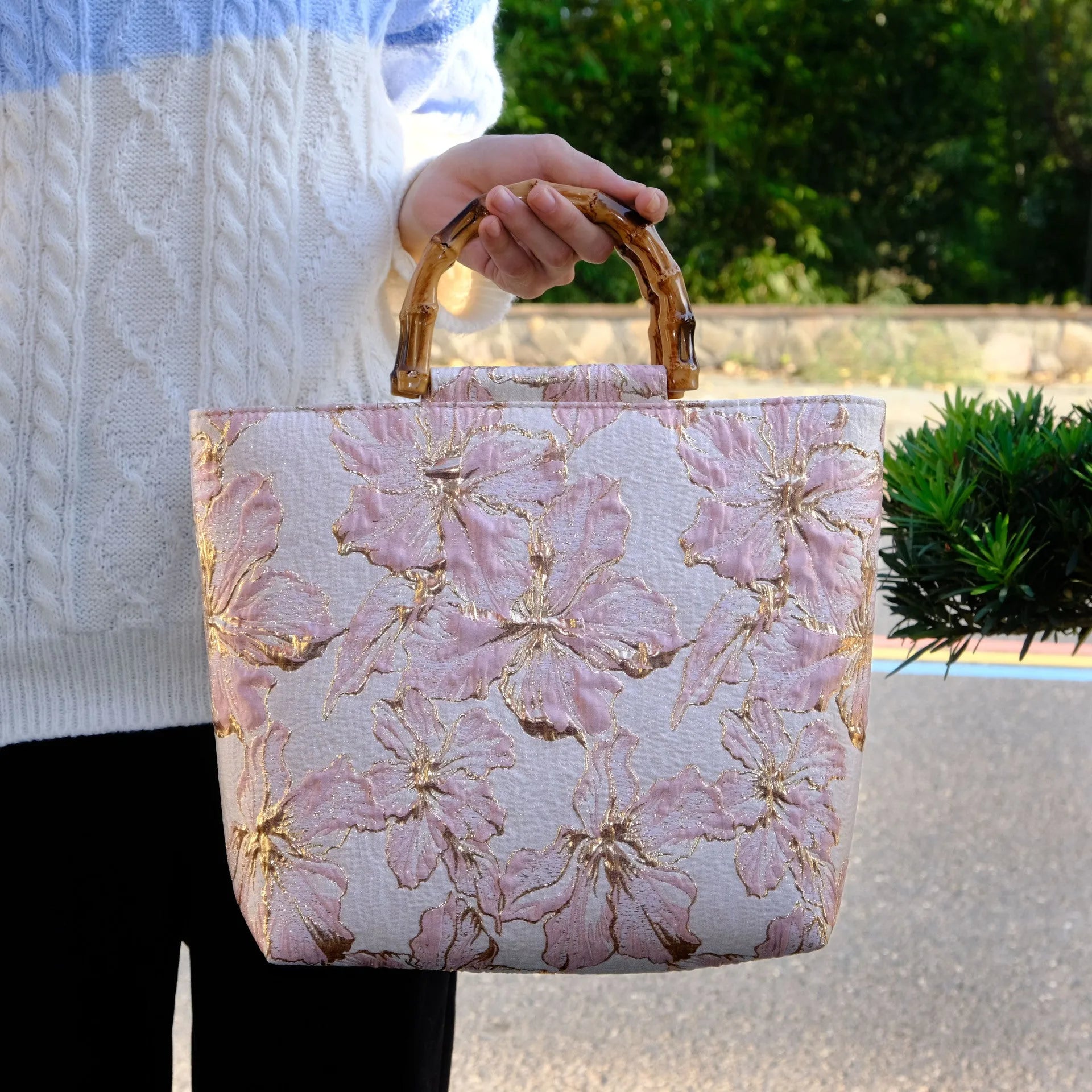 Light blue canvas bag with gold bronzing flower pattern, horizontal square shape, and dual shoulder straps.