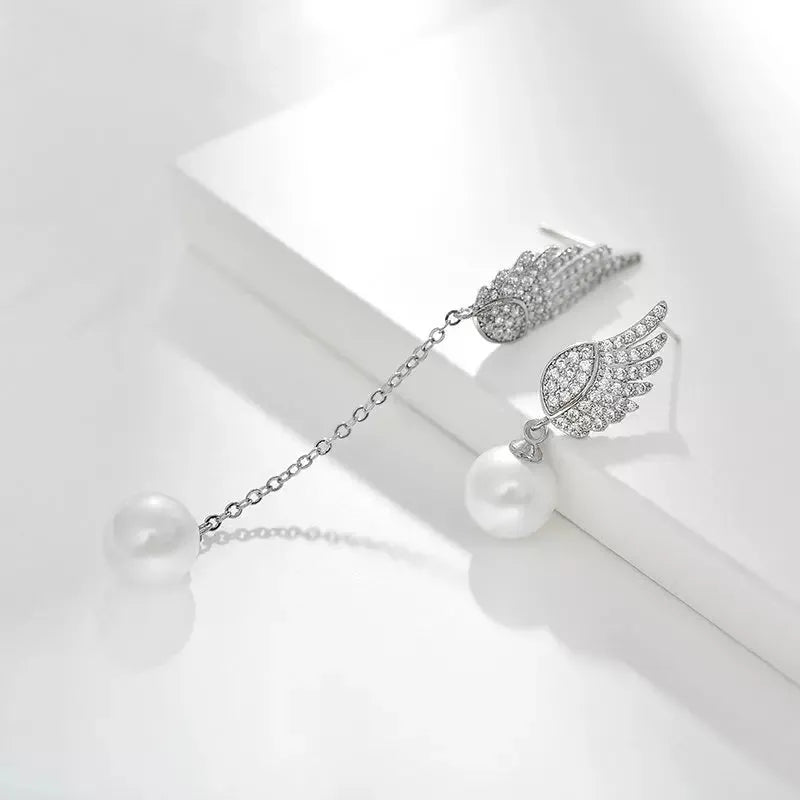 Sterling silver angel wing drop earrings with gold-plated stone inlay and diamond-cut texture.