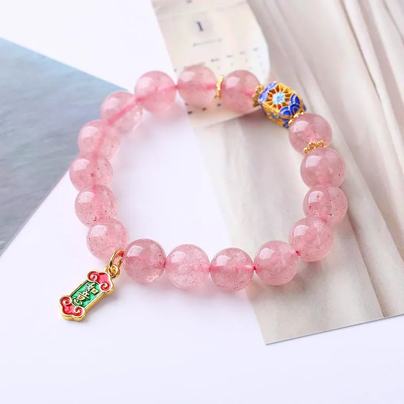 Pink strawberry quartz bracelet with Chinese Ruyi charms and engraved text on wrist