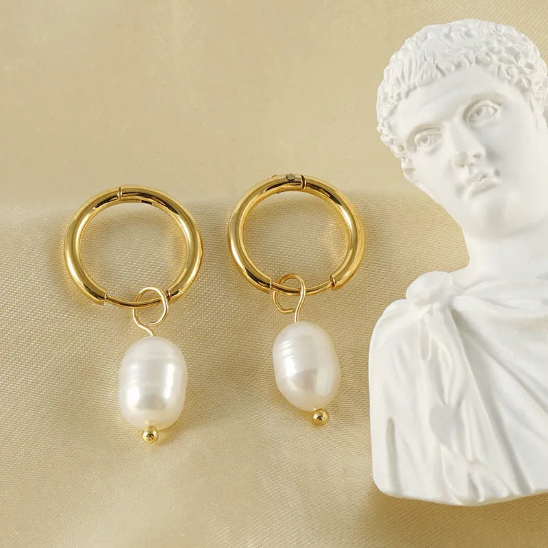 A pair of gold geometric-shaped stainless steel earrings featuring a central pearl and titanium steel posts.