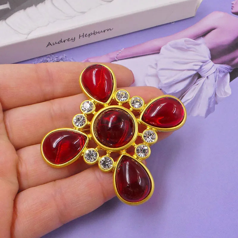 Close-up of vintage medieval baroque cross brooch with crystal accents on zinc alloy.