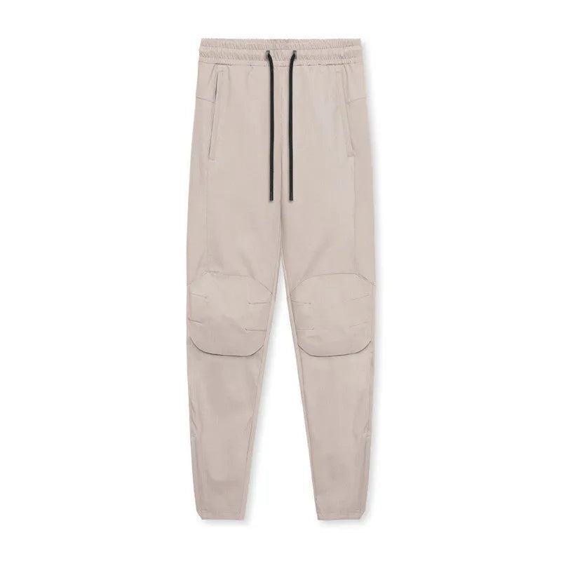 Man wearing dark grey loose-fit ankle-tied fitness trousers made of quick-drying polyester during a workout.