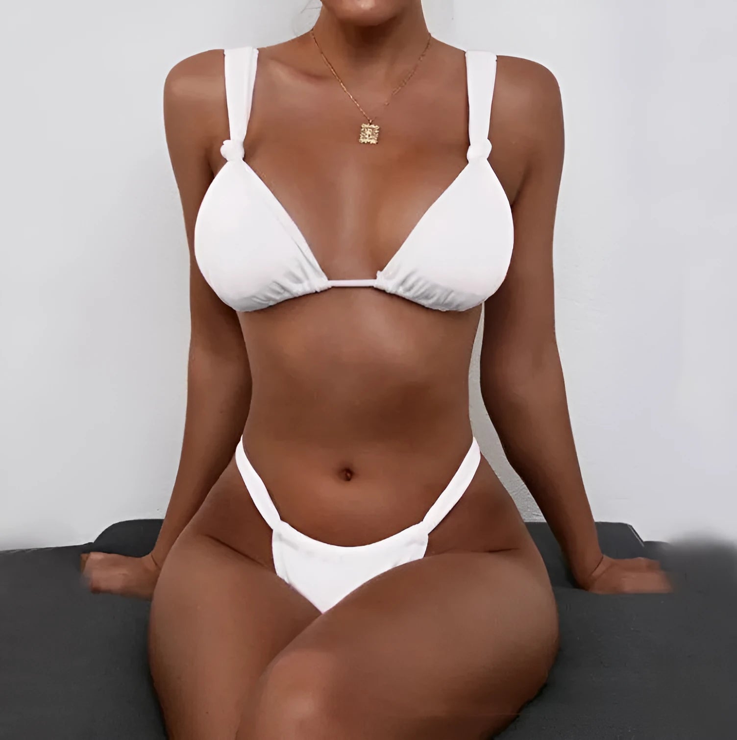 Women's pleated strap knotted bikini swimsuit in a solid colour on a mannequin.