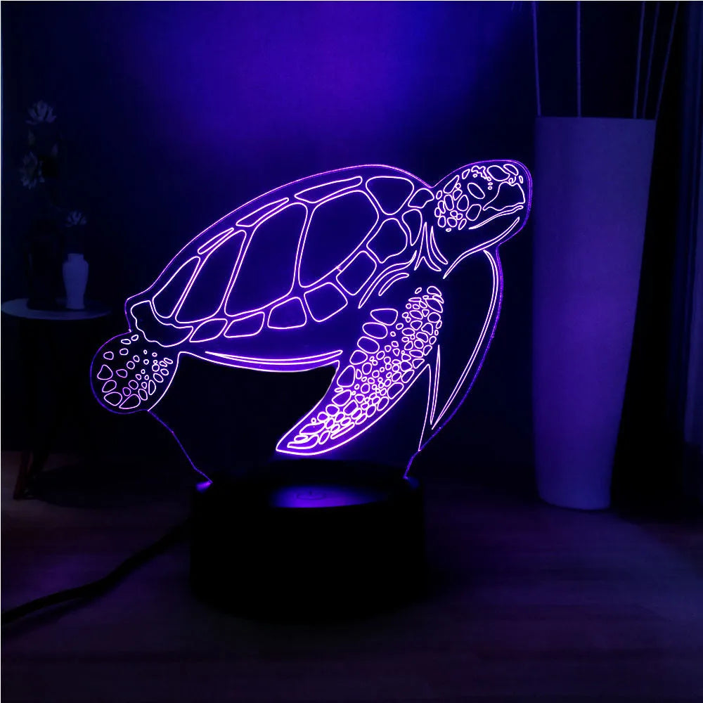 3D acrylic turtle-shaped LED night light with multi-colour illumination on a wooden surface.