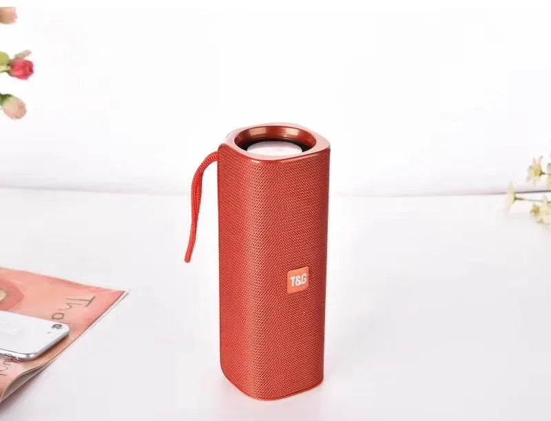 Cloth wireless Bluetooth speaker in multiple colours showing front grill and control buttons.