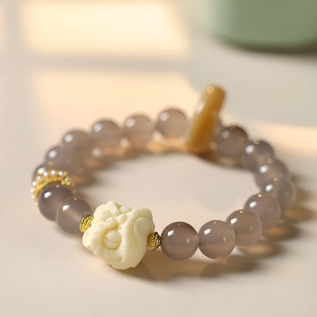 Hand-woven grey agate bracelet with ivory and mellite beads in a millet grain pattern