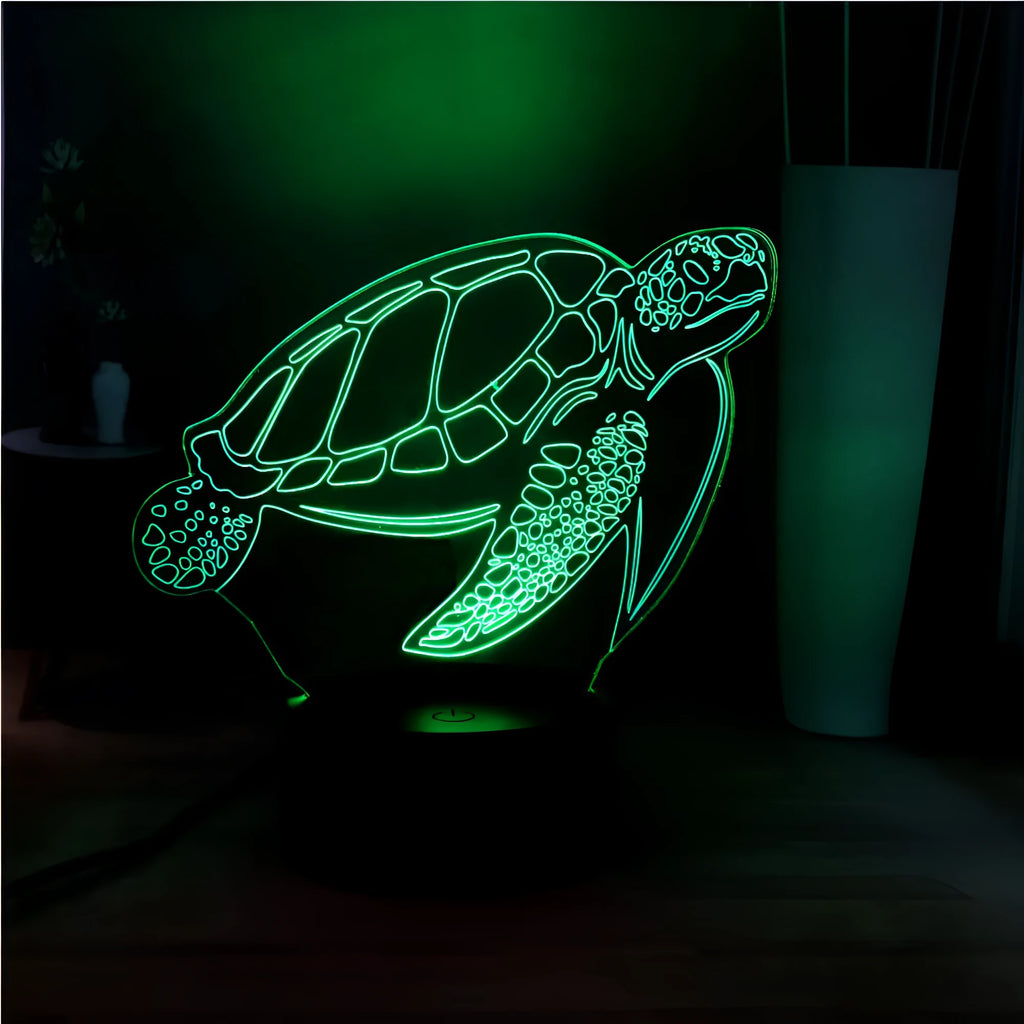 3D acrylic turtle-shaped LED night light with multi-colour illumination on a wooden surface.