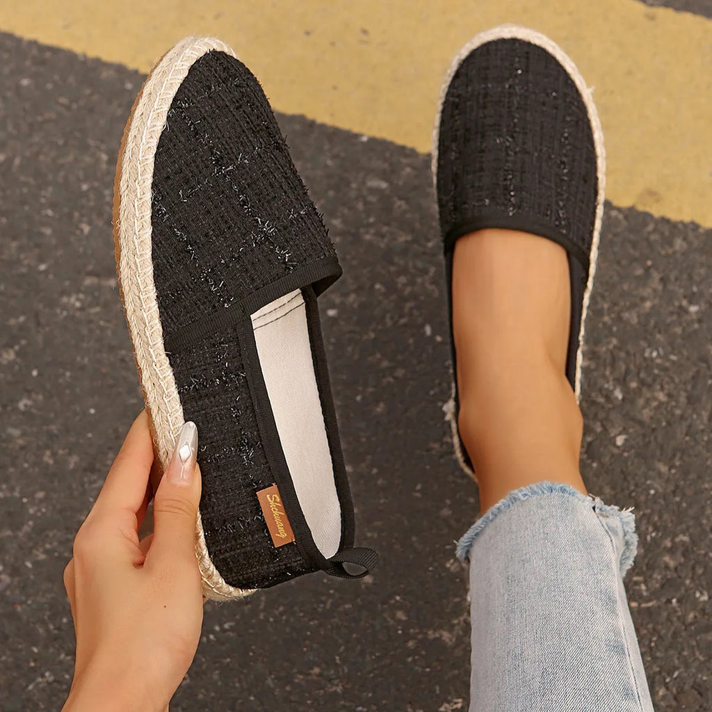 Casual beige canvas fisherman shoes with a textured rope sole on a wooden floor.