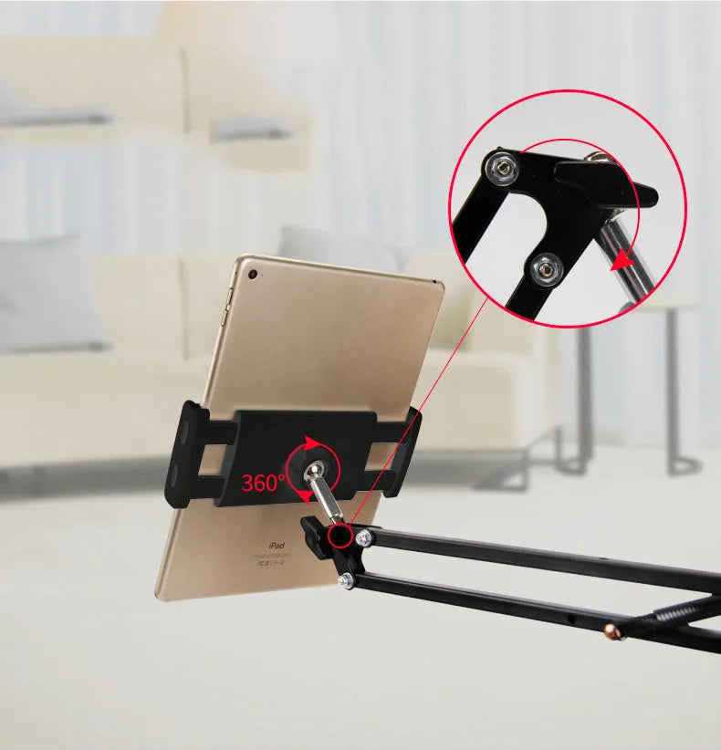A black adjustable stand holding a mobile phone on a table.