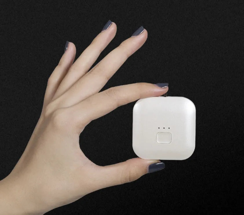 Mini USB portable air purifier necklace in pink, showing compact size and wearable design.