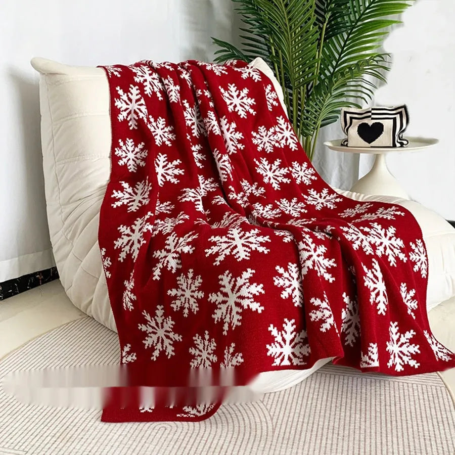 Personalised festive acrylic blanket with Christmas snowflake or reindeer pattern on a sofa.