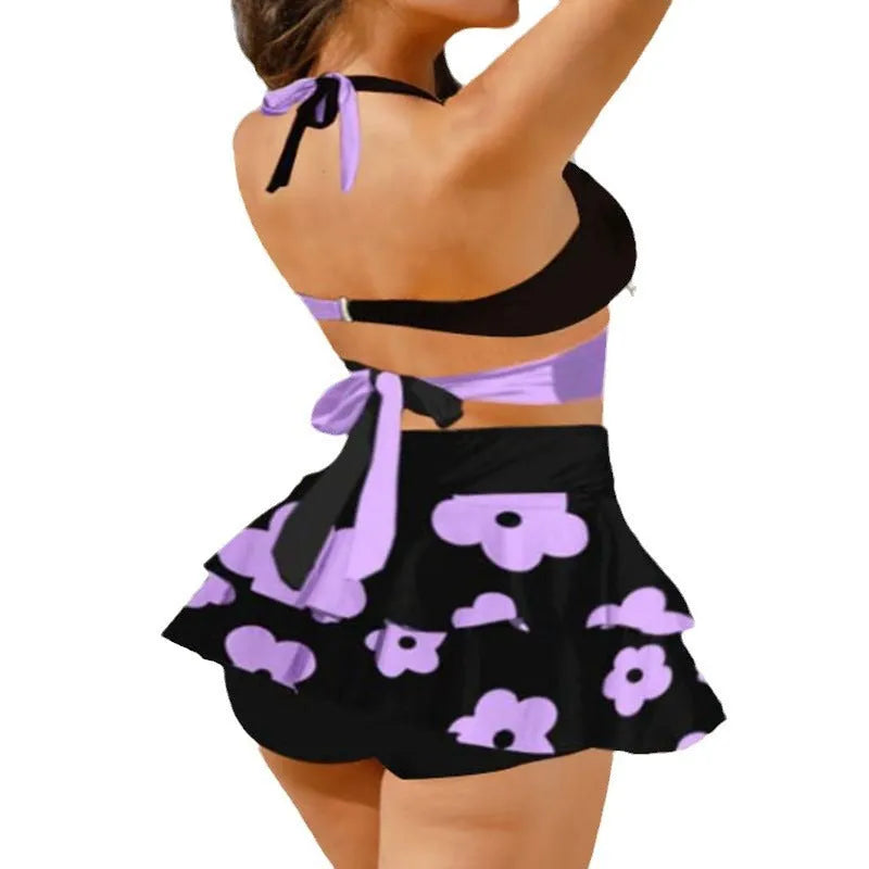 Purple women's bikini set with lace-up detail and matching high-waisted skirt.