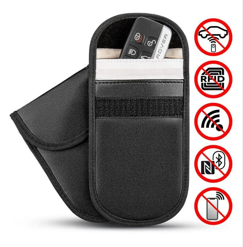 Black microfiber Faraday cage pouch for blocking car key and RFID card signals on a table.