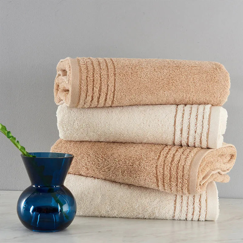 Cotton towel set in brown or beige showing bath sheet, hand towel, and face cloth sizes
