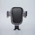 Black wireless car phone charger plugged into car dashboard with phone on charging pad, USB C port visible