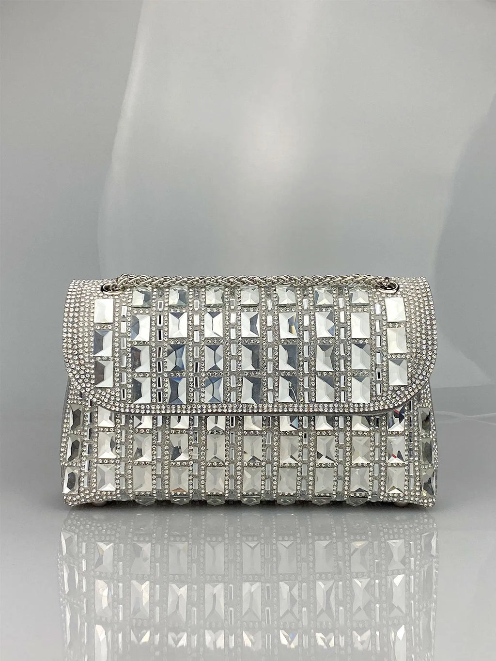 Silver rhinestone chain clutch purse with a horizontal square shape and open pocket.