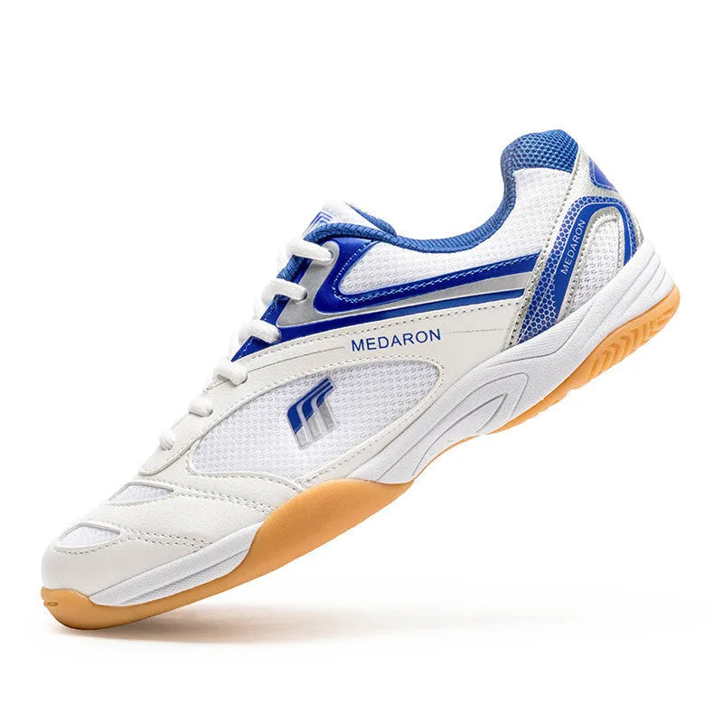 Table tennis training sneaker in white and blue with synthetic leather and mesh upper and lace-up front.
