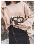 Hard PU women's shoulder bag in black with flap closure, rivet detail, and adjustable strap.