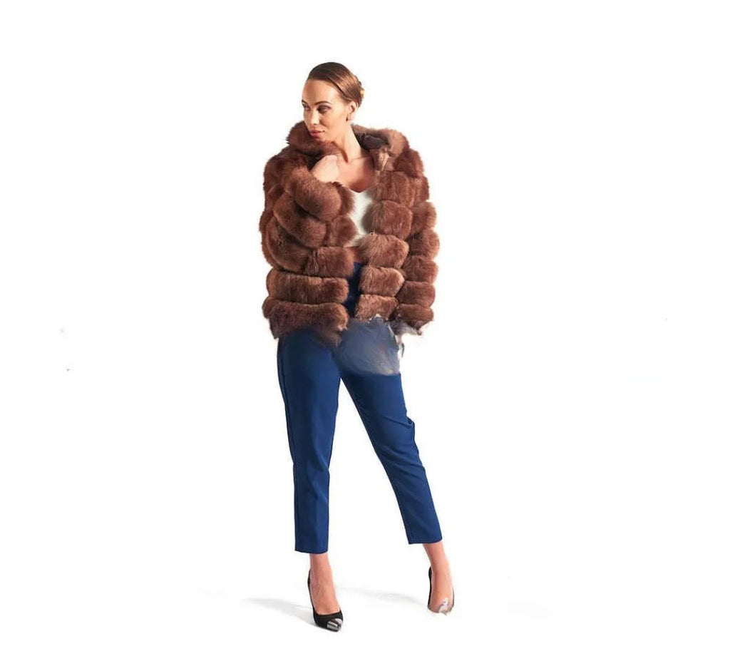 A woman modelling a loose-fitting, hooded artificial fur coat in a street fashion style.