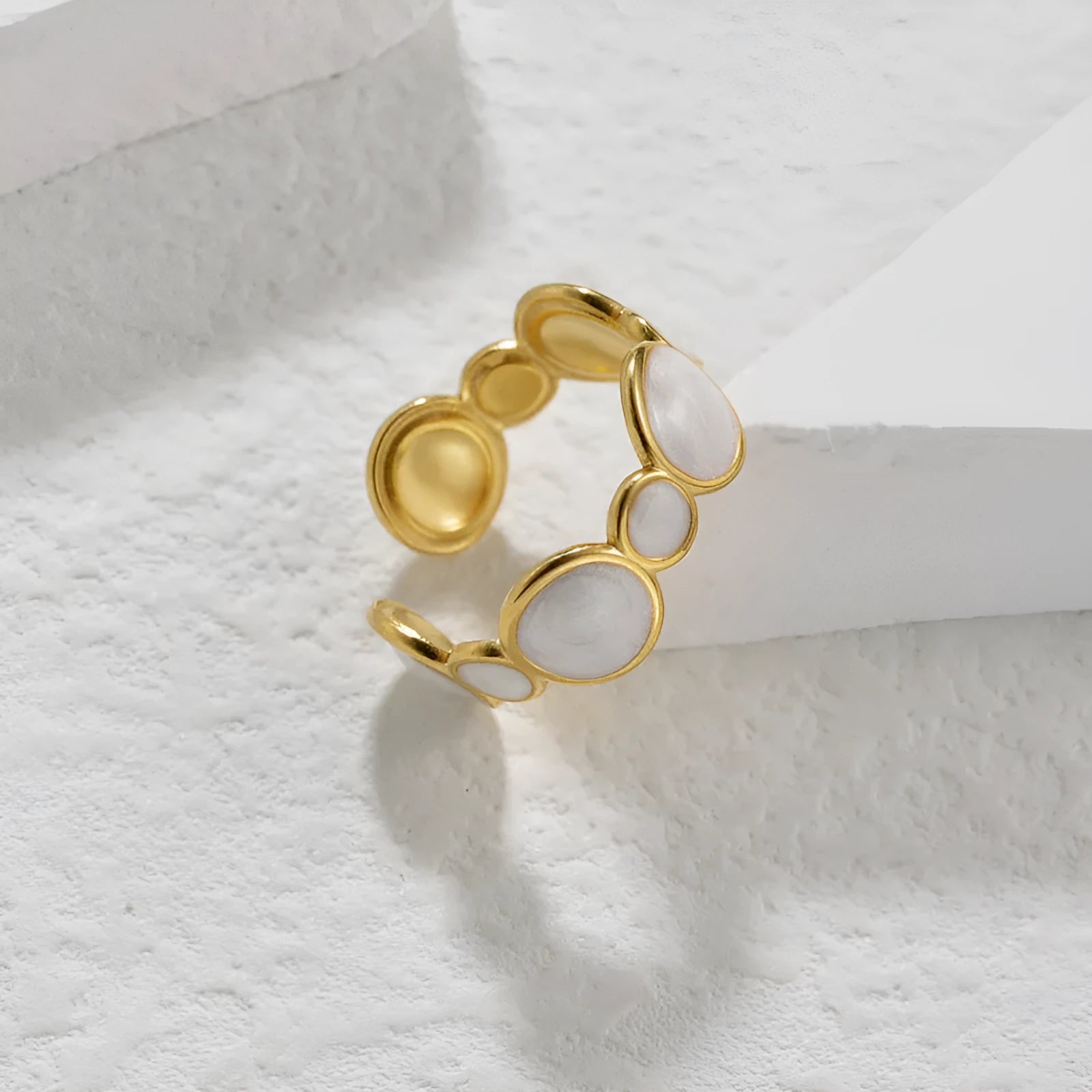 Adjustable geometric ring in stainless steel with a light luxury electroplated finish on a grey background.