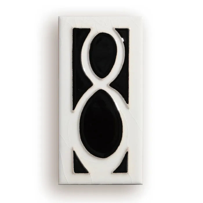 Handmade retro-style ceramic doorplate with fired enamel number, shown against a door.