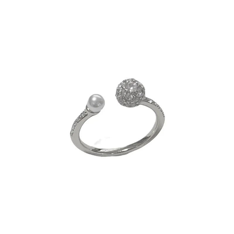 Golden open-end ring with round zircon stone on a white background.