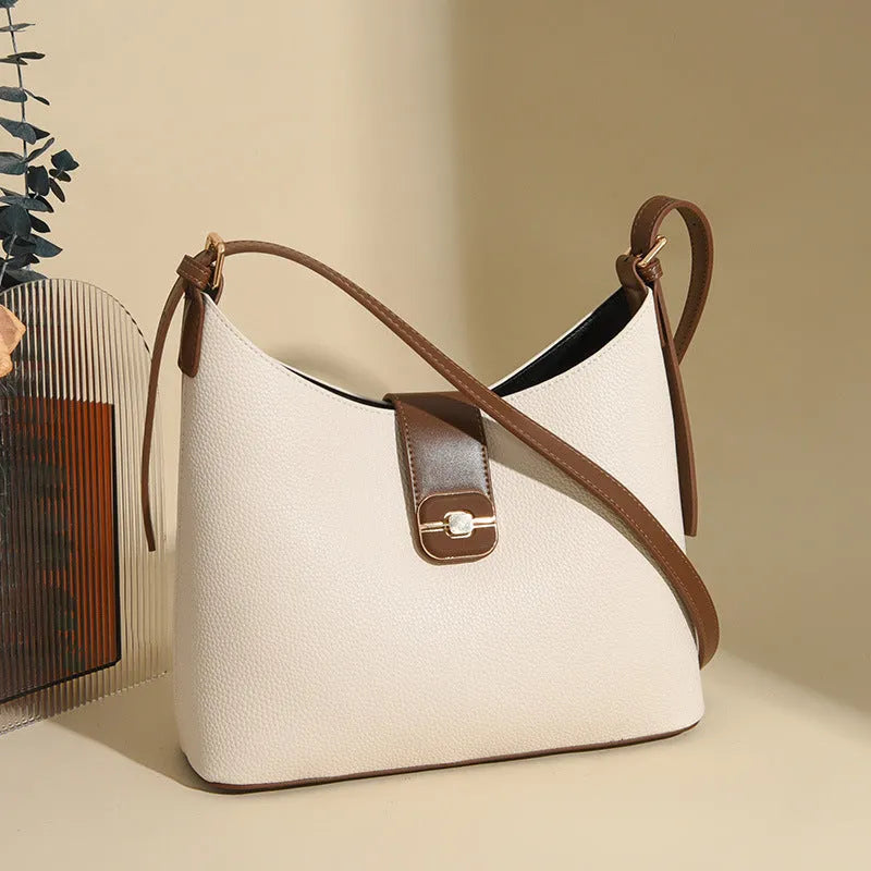 PU bucket bag in beige with contrast stitching, single shoulder strap, and open top showing internal organiser pockets.