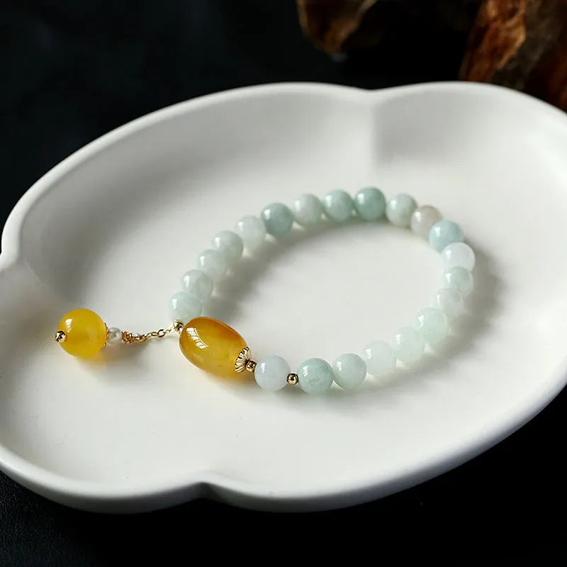 Women's ethnic bracelet with hanging red agate tassel on a gold chain.