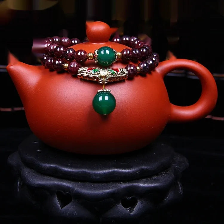 Natural garnet bracelet with 7mm beads and double-ring clasp for women, showing ordinary and upgraded quality options