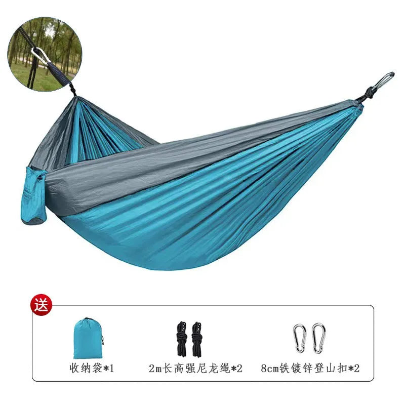 Sapphire blue parachute nylon hammock hung between trees, showing its full 270cm length and woven texture.
