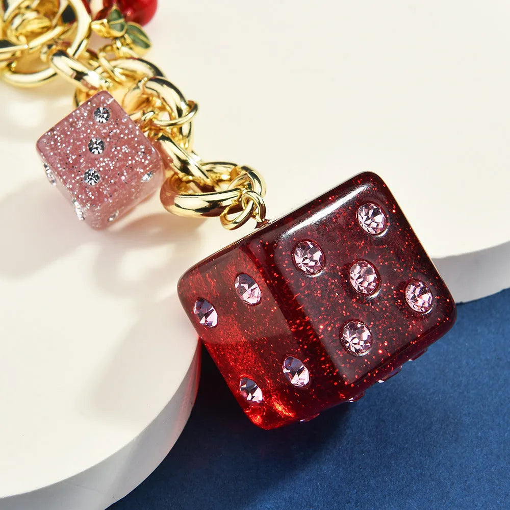 Square cherry red and silver two-tone dice keychain pendant with metal keyring on a grey background