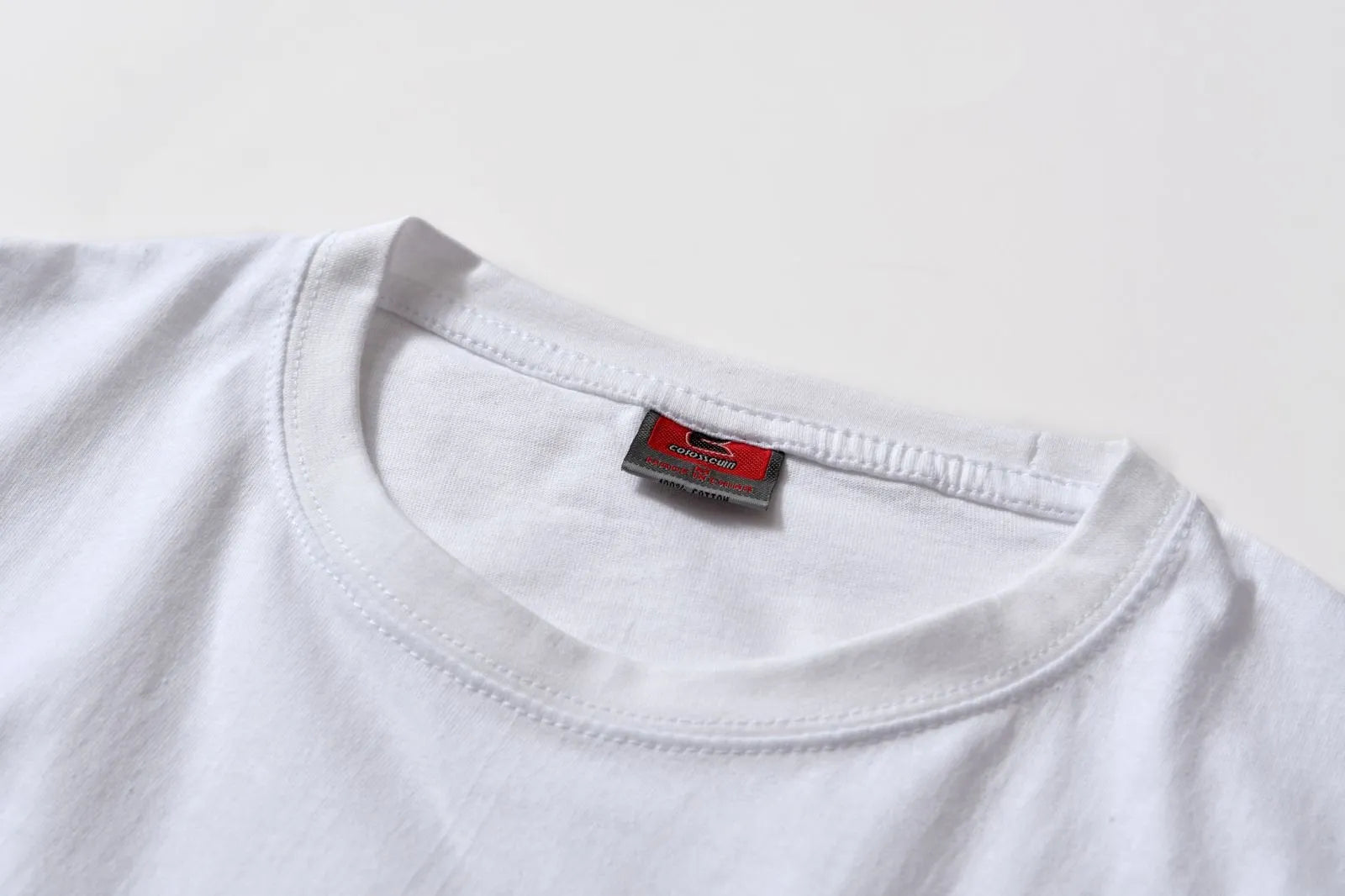 White cotton T-shirt overalls with a round neck and short sleeves, shown in a loose pullover style.