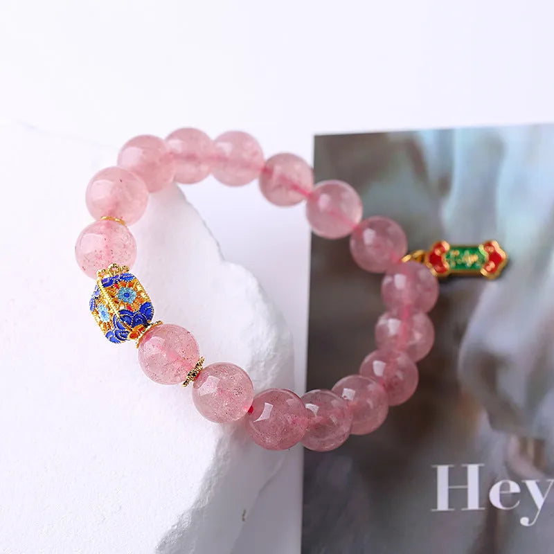 Pink strawberry quartz bracelet with Chinese Ruyi charms and engraved text on wrist