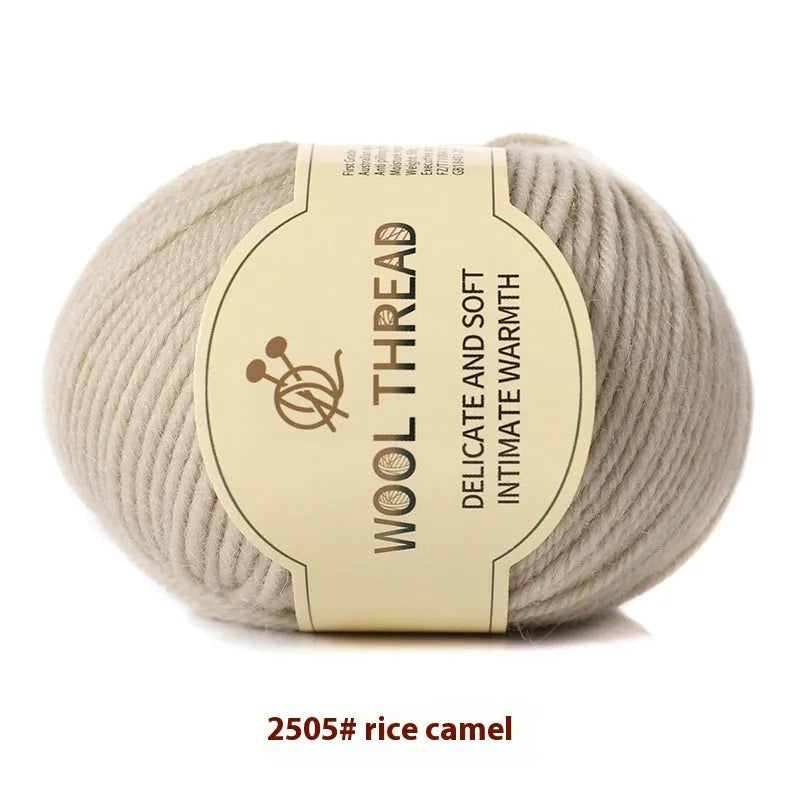 One roll of beige domestic wool hand-knitting yarn for size 10 needles next to knitting needles.