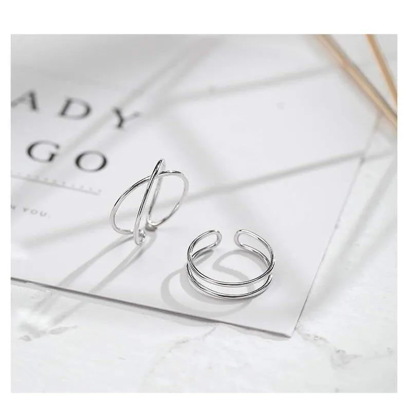 Silver plated geometric cross ring with an adjustable opening on a copper base.
