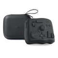TourBox NEO black video editing controller with dials and buttons on a desk next to a tablet.