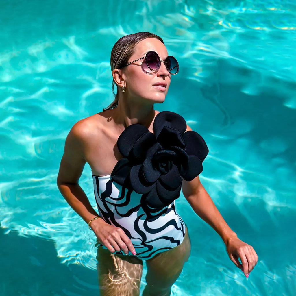 One-piece swimsuit with three-dimensional floral detail in solid colours, sized S to XL.