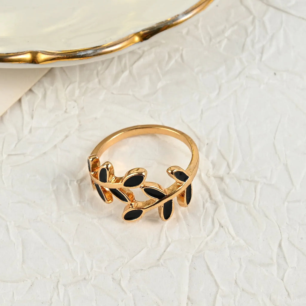 Geometric leaf ring with gold electroplated finish and simple floral design on finger
