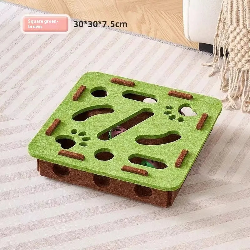 Green brown felt cat toy box with a square hole, measuring 30 cm, on a wooden floor.