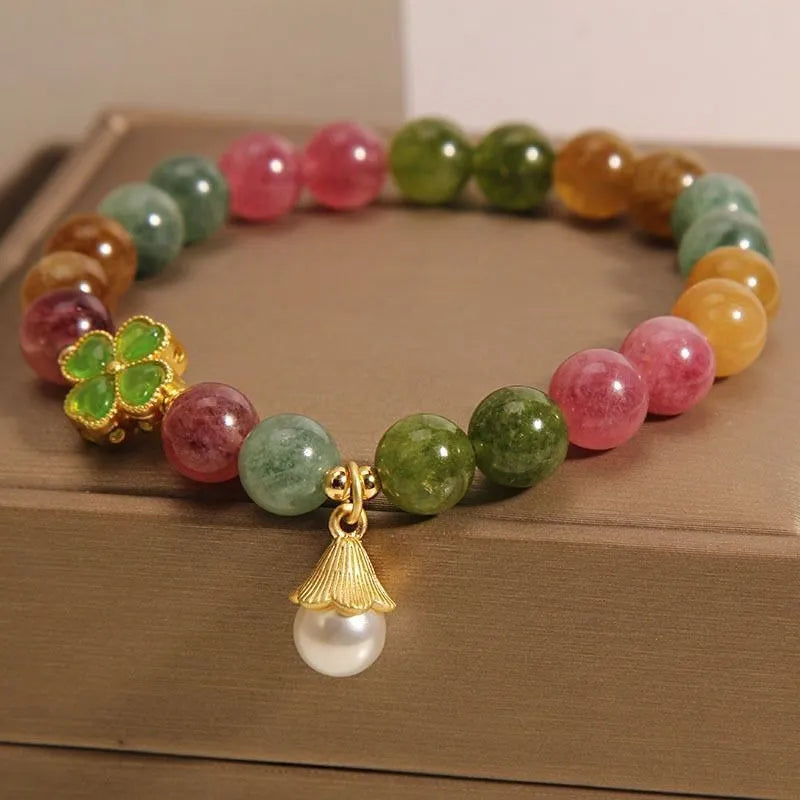 Women's silver-tone bracelet with a drop-shaped four-leaf clover pearl charm and colourful tourmaline stones on a geometric link band.